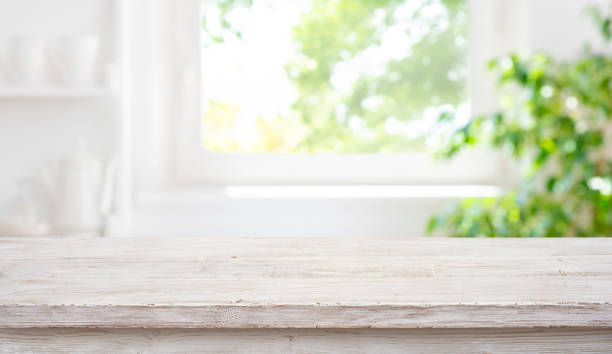 istock Empty wood table top on blur window sill and kitchen shelf background 2154405635
