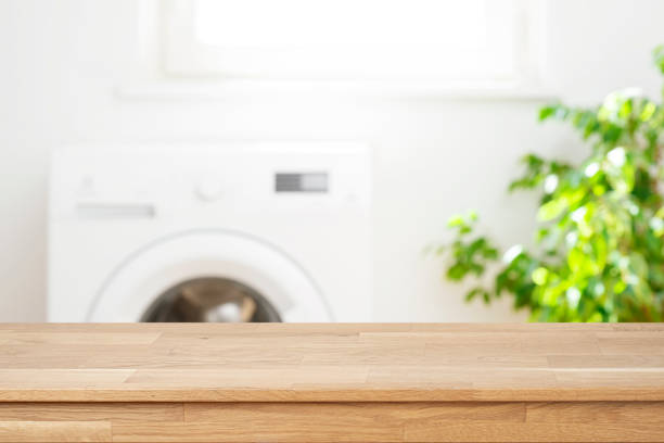 Mock-up for your design with empty wooden table in blurred laundry room