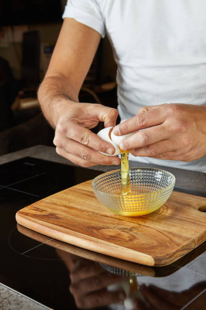 istock Making a pie in your home kitchen using several types of cheeses, crack an egg into a bowl 2154406399