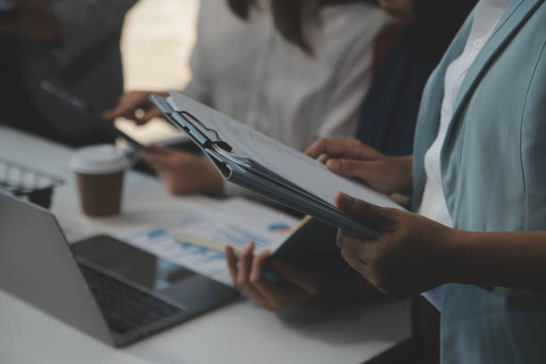 istock Financial analysts analyze business financial reports on a digital tablet planning investment project during a discussion at a meeting of corporate showing the results of their successful teamwork. 2154406515