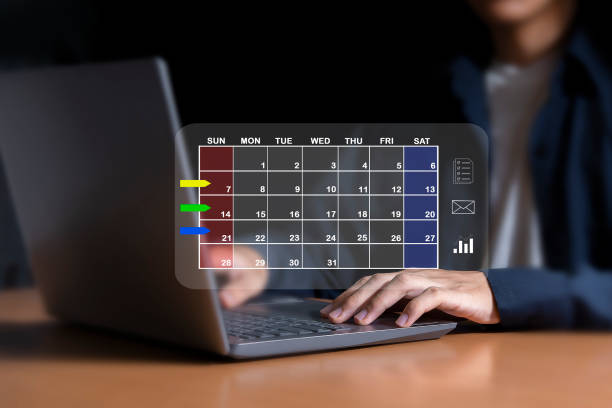 istock Businessman sets agenda on calendar as appointment planning concept. 2154407339
