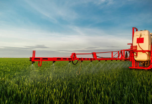 istock Tractor spraying land in sunset. 2154409140