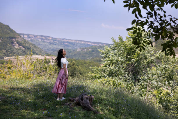 Young and beautiful woman wearing a ping skirt and a white top, wandering the alleys of  Tsarevets Fortress, Veliko Tarnovo.