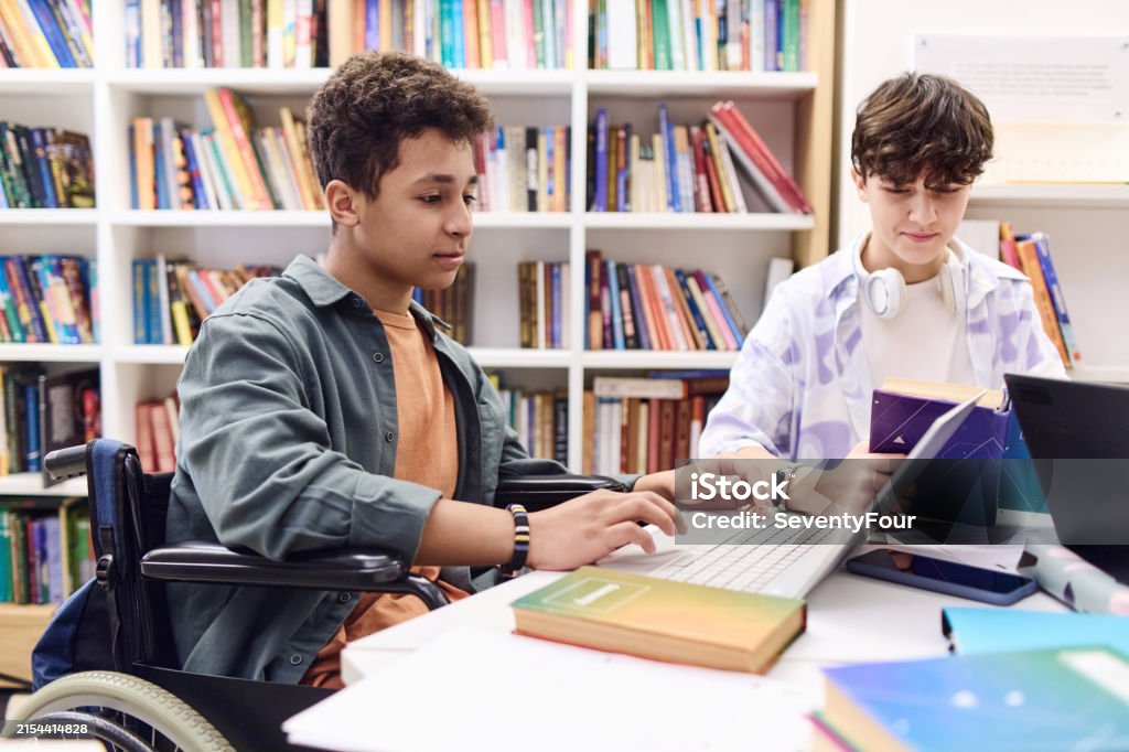 Diability Group Computer Boy With Disability Using Computer In Library With Students Stock Photo ...