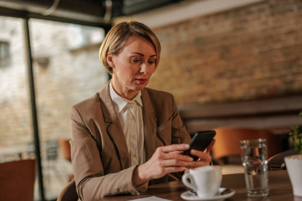 istock Classy businesswoman using a cell phone in a cafe. 2154415116