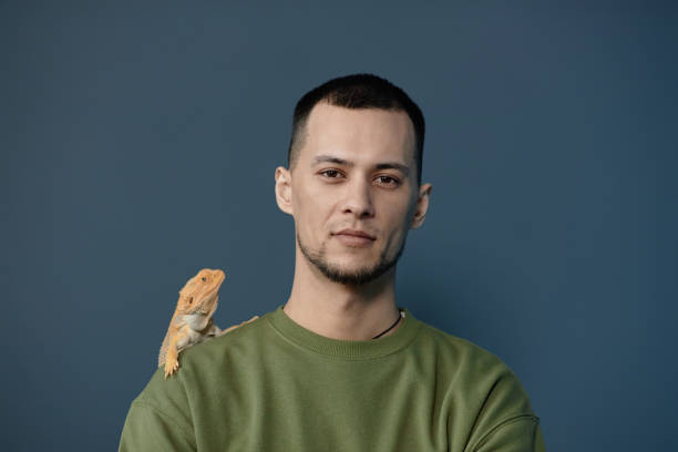 istock Man with yellow iguana on shoulder 2154415745