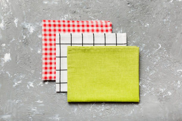 istock top view with green kitchen napkin isolated on table background. Folded cloth for mockup with copy space, Flat lay. Minimal style 2154417639