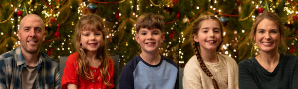 A panoramic composite image made up of portraits of a family in their home in South Shields, North East England. They are sitting in front of a twinkling Christmas tree, smiling and wearing casual clothing.