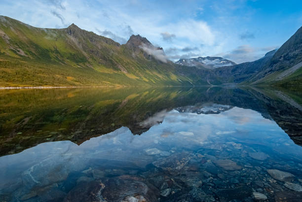 istock Pristine mountain lake reflecting majestic peaks in serene morning light 2154420784
