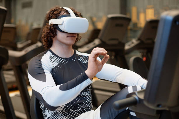 istock Man Working Out with Exercise Bike in Gym Wearing VR 2154423014