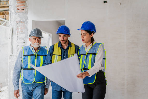 istock Coworkers talking and looking the blueprint in the house under construction 2154426857