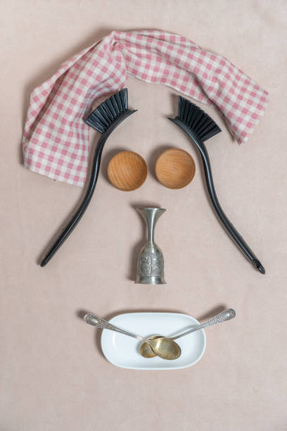 Fun face image with spoons, plastic brush, towel, glass and tea spoon. Close up