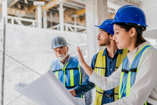 istock Coworkers talking and looking the blueprint in the house under construction 2154426878