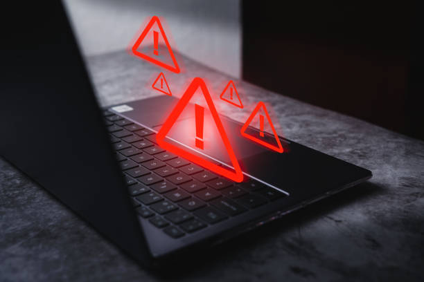 istock Laptop with hologram warning sign for notification error. 2154427357