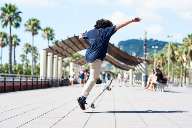 istock Active teen boy performing heel flip on skateboard in sunlight. 2154430071