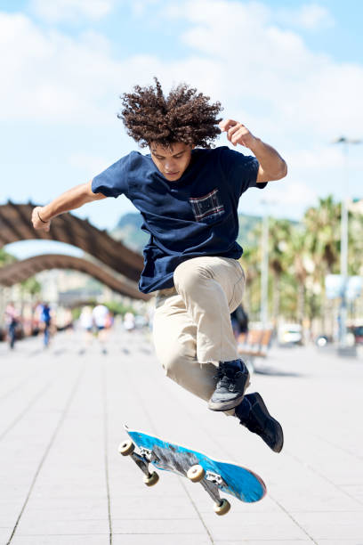 istock Boy with afro hairstyle performing skateboarding trick. 2154430073