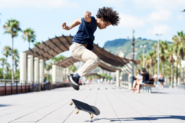 Captured skateboarder performing trick in sunny street.