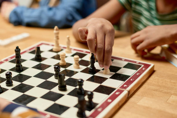 istock Hand of boy moving white pawn on board 2154432725