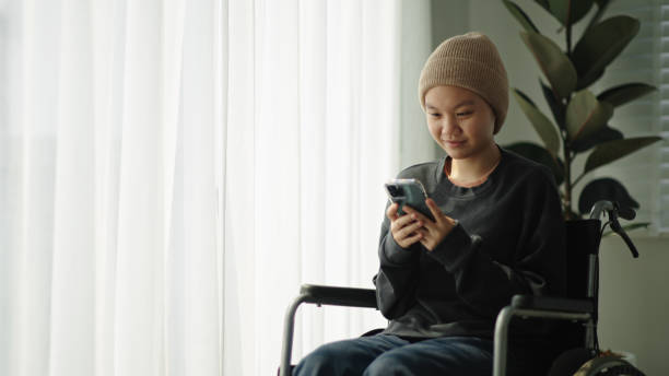 istock Teenager patient using smartphone on wheelchair. 2154437277