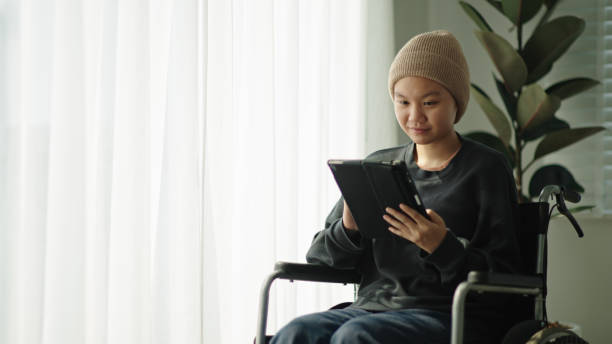 istock Teenager patient using digital tablet while sitting on wheelchair. 2154437832