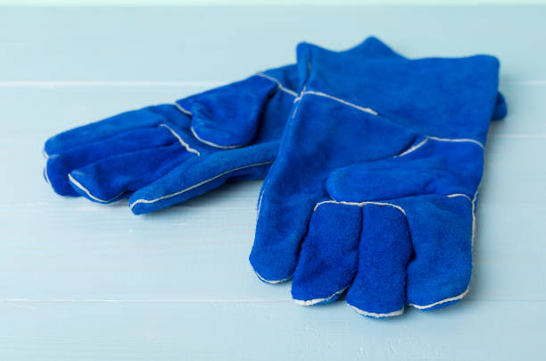 Blue construction gloves on wooden table