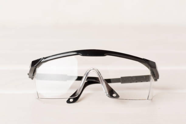 istock Black safety glasses on wooden table 2154438859