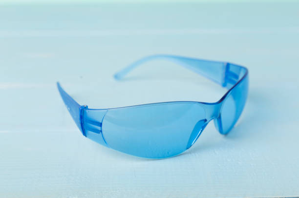 Blue safety glasses on wooden table