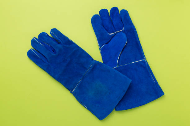 istock Blue construction gloves on color background, top view 2154438896