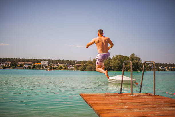istock Men jumping in the lake on a hot summer day 2154439268