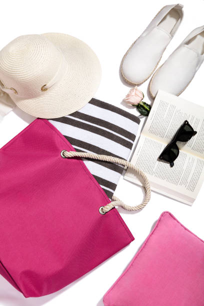 Beach accessories, espadrilles, sunglasses on book with handbag and straw hat isolated on white background(with clipping path)