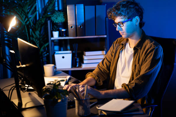 istock Businessman concentrating on pc on project at neon light office. Gusher. 2154443373