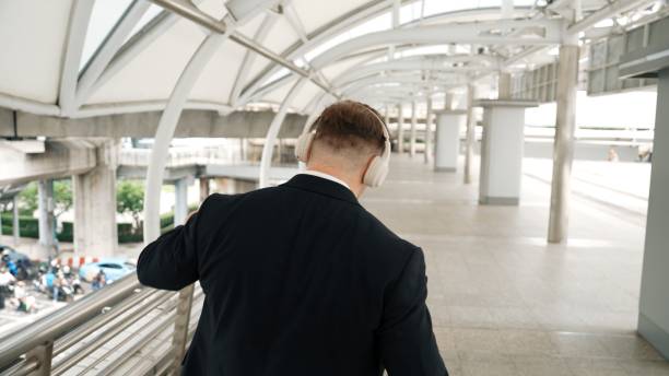 istock Happy business man dancing while wear headphone at bridge. Back view. Urbane. 2154444899