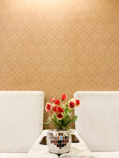 Photo of flowers in a sparkling vase, with a background of brown wallpaper and a white sofa