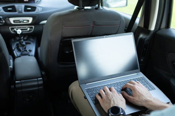 istock Man is travelling by car on the back seat and using wireless devices, laptop. Flexible working outside. Modern virtual financial consultations. 2154446238