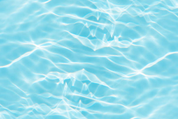 istock Blue water with ripples on the surface. Defocus blurred transparent blue colored clear calm water surface texture with splashes and bubbles. Water waves with shining pattern texture background. 2154450096