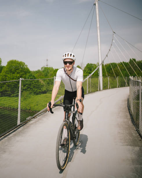 istock Road bicyclist rides across suspension bridge 2154452070