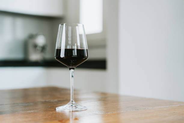 istock A glass of red wine on the table with kitchen in the background 2154457871