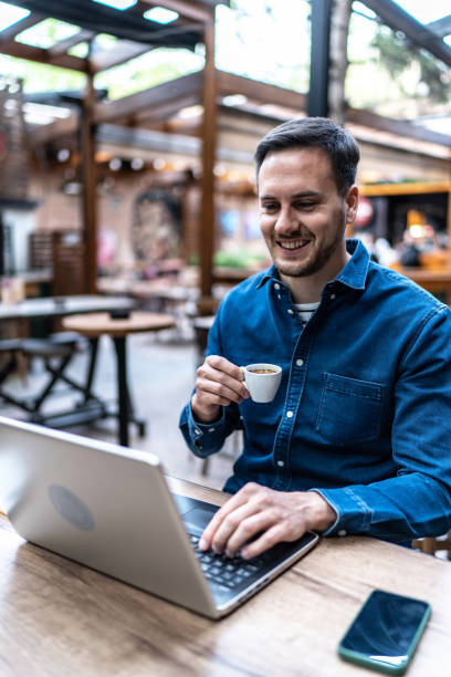 istock Young businessman working on laptop at cafe 2154463461