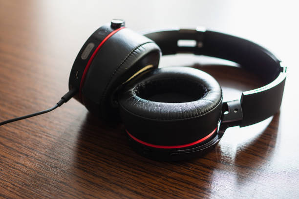 Black headphone on the wooden table.
