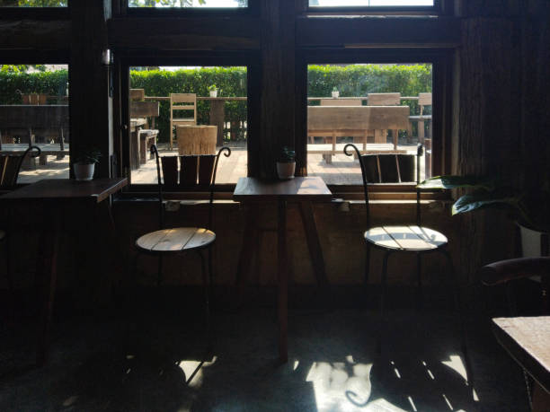 Dramatic shading and sun lighting relaxation corner with wooden surface tables and chairs