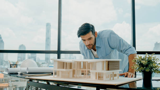 istock Closeup of skilled engineer check, inspect, look at house model. Tracery 2154471333