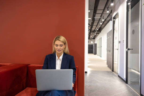istock Professional female wearing suit working on computer in office hall 2154472053