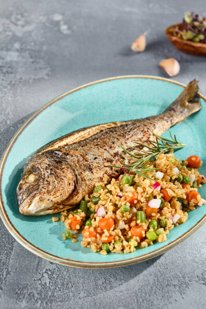 istock Grilled Dorado with Bulgur and Vegetable Medley Elegantly Served on a Turquoise Plate 2154473298