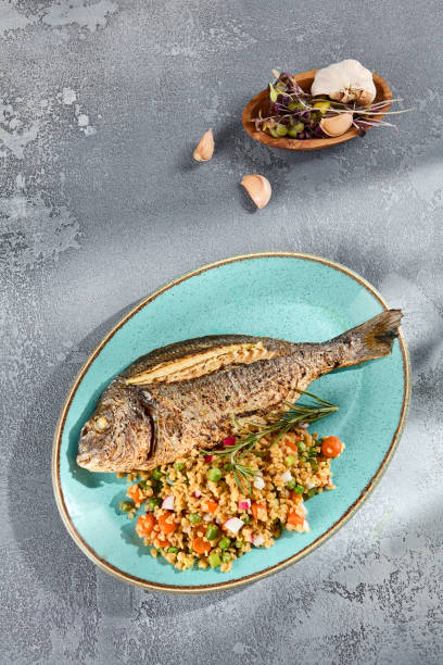 istock Grilled Dorado with Bulgur and Vegetable Medley Elegantly Served on a Turquoise Plate 2154473379