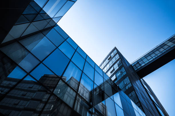Sunlit modern glass buildings showcasing architectural beauty and urban development against a blue sky.