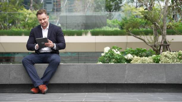 istock Smart businessman sitting while writing on tablet and planning strategy. Urbane 2154476646