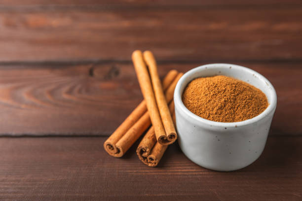 istock Cinnamon powder on background. Spicy spice for baking, desserts and drinks. Fragrant ground cinnamon. Cinnamon stick. Place for text. Copy space. 2154476797