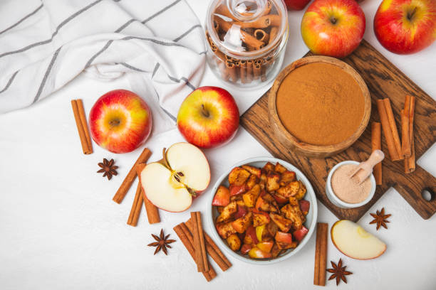 istock Apples with cinnamon on background. Fragrant red spiced apples with cinnamon sticks and star anise. Apple slices with spicy spices. Place for text. Copy space. Harvesting. Fruits. 2154476994
