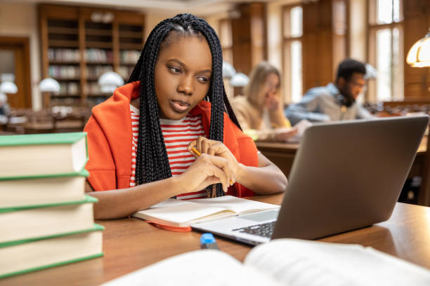 istock Long-haired young woman studying in the library 2154478932