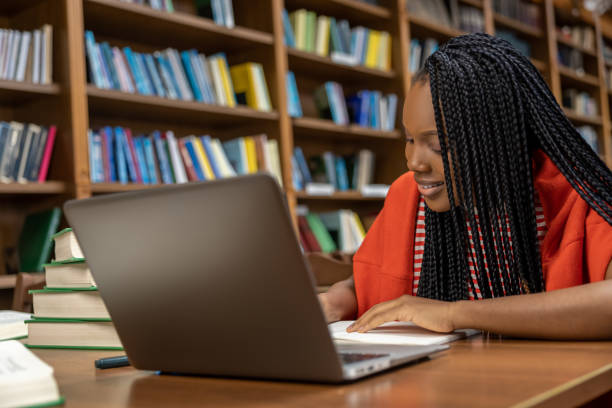 istock Long-haired young woman studying in the library 2154478940
